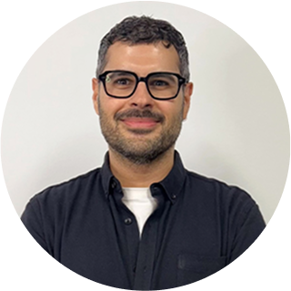Carlo Yousif, Digital Project Manager at Perceptiv Media, smiling in a round portrait, wearing glasses and a black shirt, representing the agency's commitment to creativity and strategy in digital marketing.