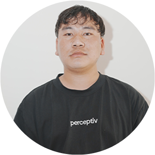 Sushil Thapa, WordPress Developer at Perceptiv Media, wearing a black t-shirt with the logo, posed against a neutral background.