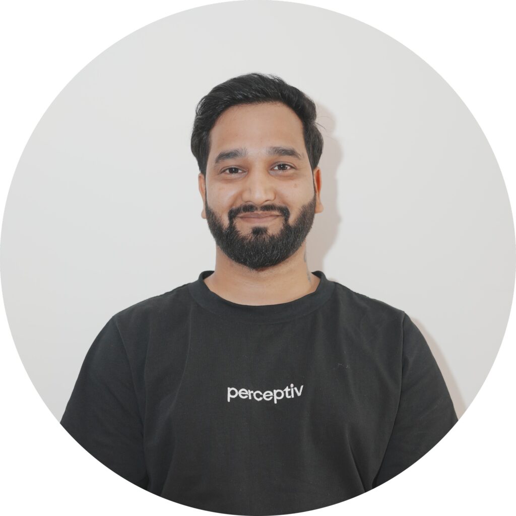 Pankaj Bahuguna, WordPress and Shopify Developer at Perceptiv Media, smiling in a black t-shirt with the company logo, showcasing the team’s commitment to innovative web development.