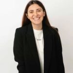Smiling woman in a black blazer, representing client satisfaction with Perceptiv Media's SEO services for hospitality businesses.