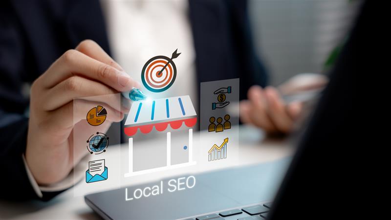 Hand interacting with digital icons representing local SEO strategies, business growth, and marketing analytics on a laptop screen.
