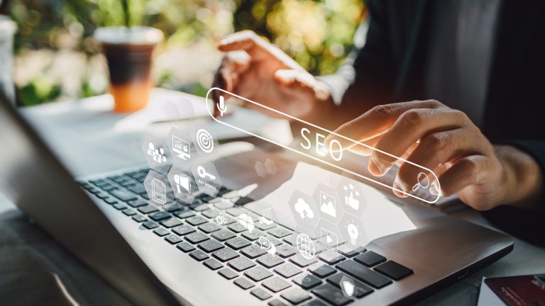 Person typing on laptop with SEO icons overlay, representing digital marketing strategies for Sydney startups and businesses.